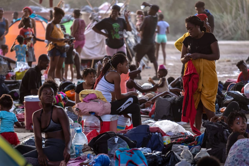 Immigrants sit and lie under the international bridge at a migrant camp on the US-Mexico border on 21 September 2021 in Del Rio, Texas. The immigrants, mostly from Haiti have numbered as high as 14,000 at the camp.