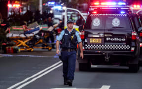 A police officer reacts outside the Westfield Bondi Junction shopping mall after a stabbing incident in Sydney on April 13, 2024. Australian police on April 13 said they had received reports that "multiple people" were stabbed at a busy shopping centre in Sydney. (Photo by David GRAY / AFP)