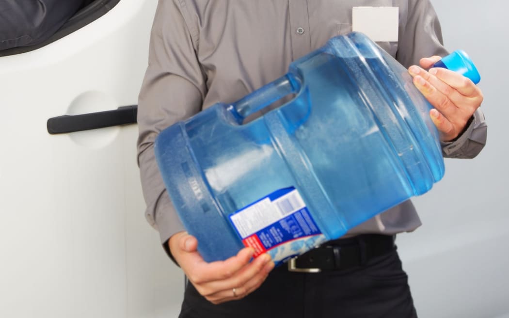 44642710 - water delivery service man with big bottle.