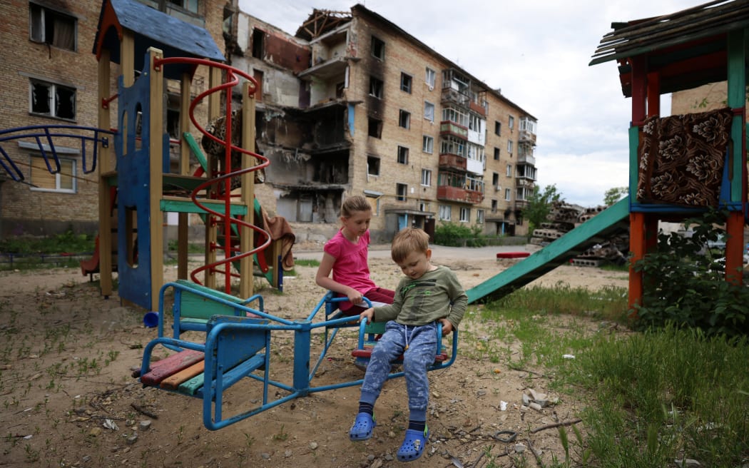 Children play in front of a bombed out apartment in the village of Horenka which is on the north-west border of Kyiv city on 5 June 2022.
