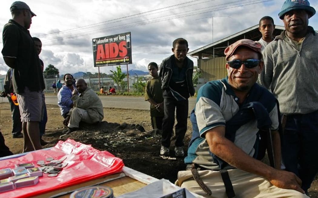 Residents sell their goods near a anti-Aids billboard in Mount Hagen, 18 August 2007.