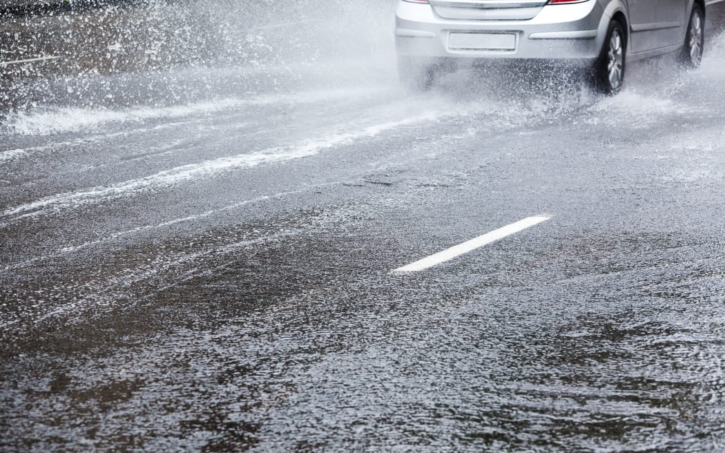 Car driving in heavy rain. Street flooding.