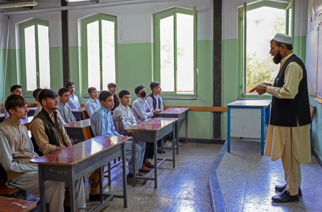 Boys attend their class at Istiklal school in Kabul on September 18, 2021. (Photo by BULENT KILIC / AFP)