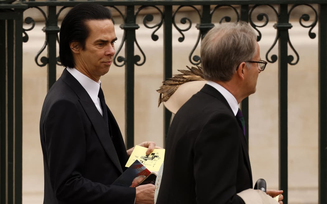 Nick Cave (L) arrives at Westminster Abbey in central London on May 6, 2023, ahead of the coronations of Britain's King Charles III and Britain's Camilla, Queen Consort. - The set-piece coronation is the first in Britain in 70 years, and only the second in history to be televised. Charles will be the 40th reigning monarch to be crowned at the central London church since King William I in 1066. Outside the UK, he is also king of 14 other Commonwealth countries, including Australia, Canada and New Zealand. Camilla, his second wife, will be crowned queen alongside him, and be known as Queen Camilla after the ceremony. (Photo by Odd ANDERSEN / AFP)