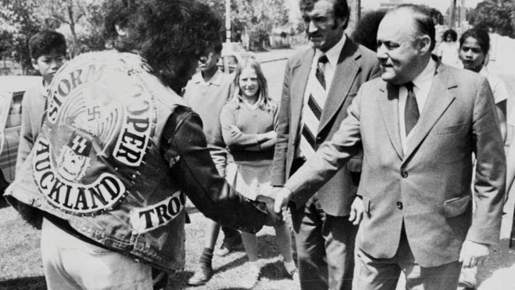 Prime Minister Robert Muldoon shakes hands with a gang member employed on a work scheme, Bairds Road, Otara, November 2 1979.