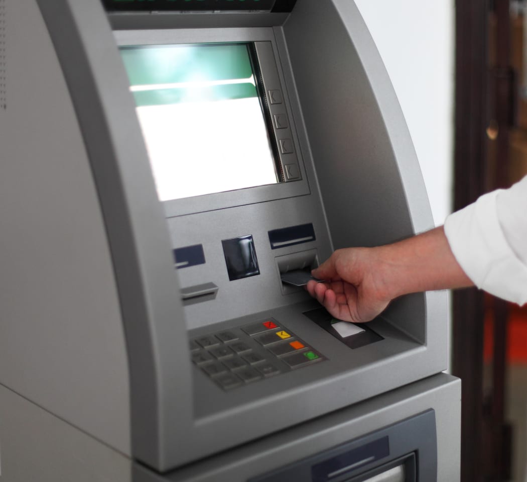 Close up of hand of a man using banking machine
