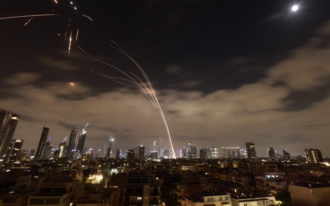 Israeli air defence systems are activated to intercept Iranian missiles over the Israeli city of Tel Aviv amid a fresh barrage of Iranian rockets on June 16, 2025. The Israeli military said early on June 16 that it was striking surface-to-surface missile sites in Iran, its latest move in three days of escalating conflict between the rival states. "The IDF is currently striking surface-to-surface missile sites in central Iran," Israel Defense Forces (IDF) spokesman Nadav Shoshani wrote on X. "We are operating against this threat in our skies and in Iranian skies." (Photo by Menahem Kahana / AFP)