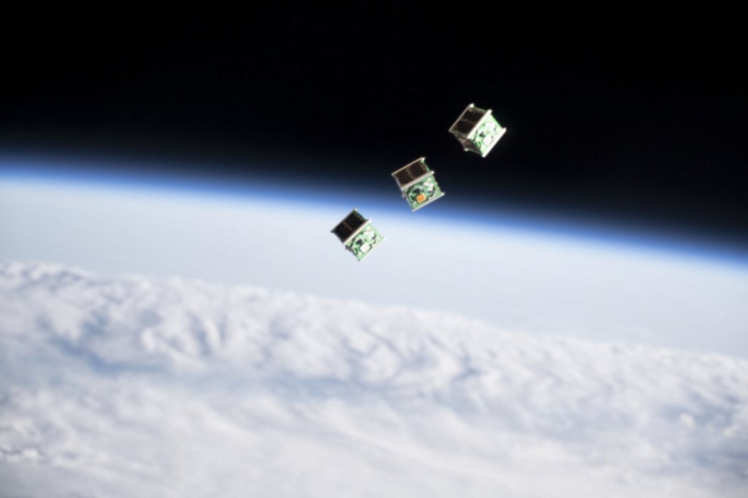 This NASA photo obtained released June 19, 2019 shows a set of three CubeSats pictured shortly after being ejected from the Japanese Small Satellite Orbital Deployer attached to a robotic arm outside of the Japan Aerospace Exploration Agency's Kibo l