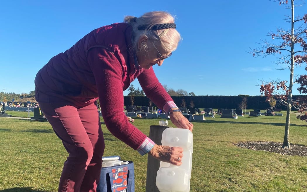 Lal Mulligan filling her water containers at the Ashburton Cemetery.