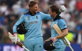 England's captain Eoin Morgan (R) and England's Joe Root celebrate victory at close of play during the 2019 Cricket World Cup second semi-final