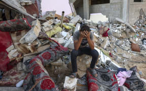 A Palestinian youth reacts as he sits on the rubble of a destroyed home following an Israeli military strike on the Rafah refugee camp, in the southern of Gaza Strip on Octobers 15, 2023, amid the ongoing battles between Israel and the Palestinian Islamist group Hamas. Thousands of people, both Israeli and Palestinians have died since October 7, 2023, after Palestinian Hamas militants based in the Gaza Strip, entered southern Israel in a surprise attack leading Israel to declare war on Hamas in Gaza on October 8. (Photo by MOHAMMED ABED / AFP)