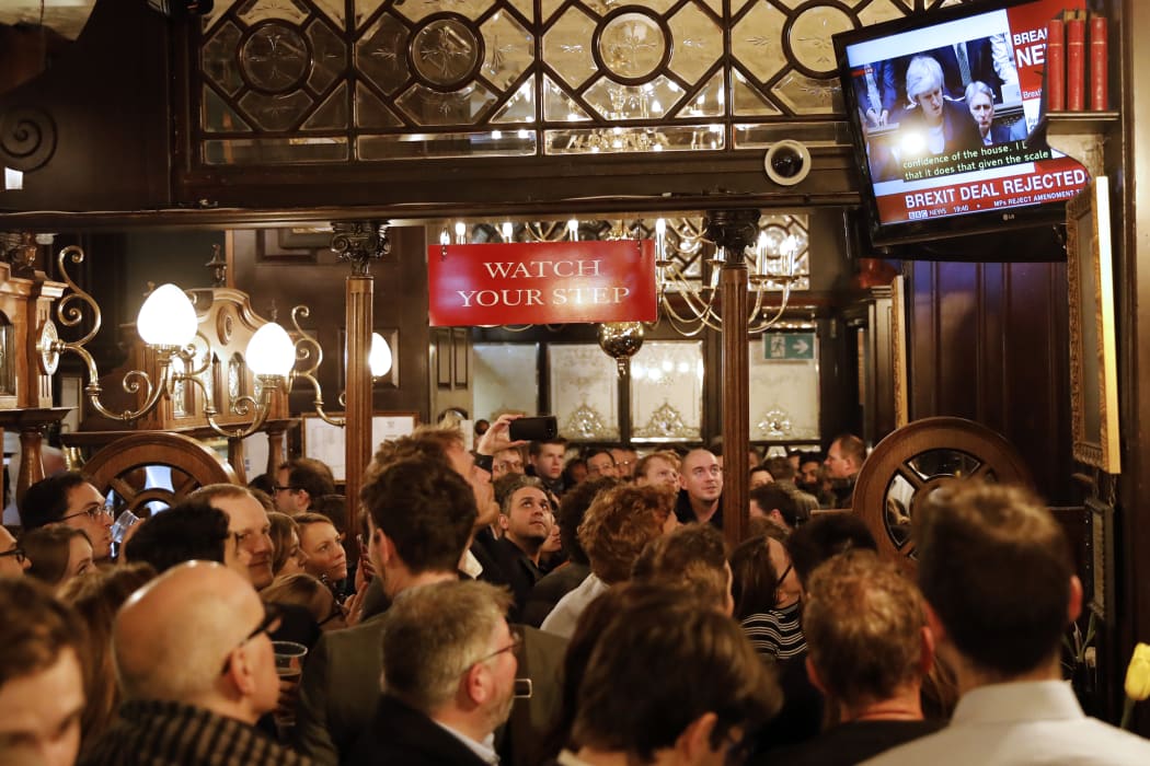 Member of the public watch a television screen in the Red Lion on Whitehall, as MPs vote overwhelmingly against the government's Brexit deal.