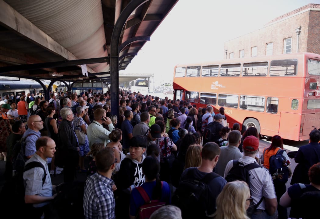 Commuters wait for buses after trains were cancelled.
