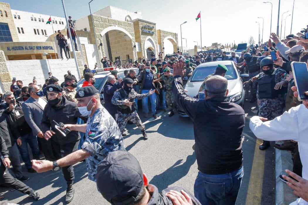 People stand on the side as Jordan's King Abdullah II arrives at al-Hussein New Salt Hospital in the town of Salt.