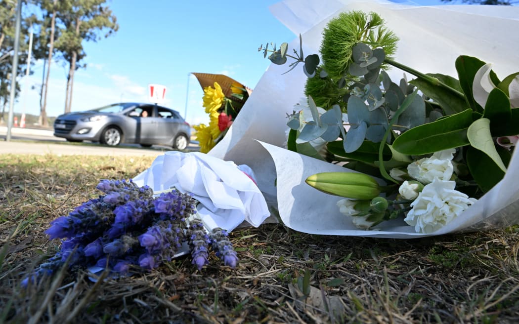 Flowers are left by the road some 500 meters from the site of a bus crash, where 10 people from a wedding party were killed, in Cessnock, in Australia's Hunter wine region north of Sydney.