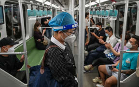People travel on a subway in the Jing'an district of Shanghai on June 1, 2022, after the end of the lockdown that kept the city two months with heavy-handed restrictions. (Photo by Hector RETAMAL / AFP)