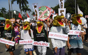 Protesters wearing crocodile masks march during an anti-corruption rally near a park on Manila on November 30, 2025.