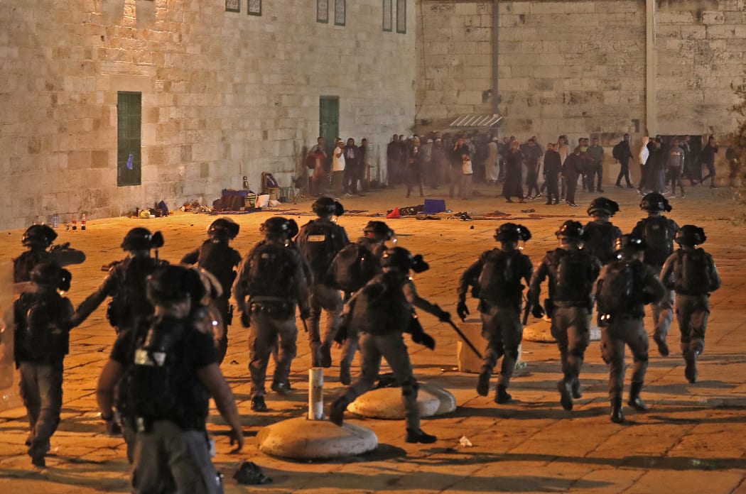 Israeli security forces advance amid clashes with Palestinian protesters at the al-Aqsa mosque compound in Jerusalem,