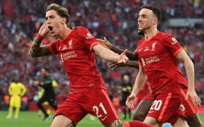 Liverpool's Greek defender Kostas Tsimikas (L) celebrates with teammates after scoring a goal during the penalty sessions of the English FA Cup final football match between Chelsea and Liverpool, at Wembley stadium, in London, on May 14, 2022. - Liverpool beat Chelsea on penalties to win the FA Cup final. (Photo by Glyn KIRK / AFP) / NOT FOR MARKETING OR ADVERTISING USE / RESTRICTED TO EDITORIAL USE