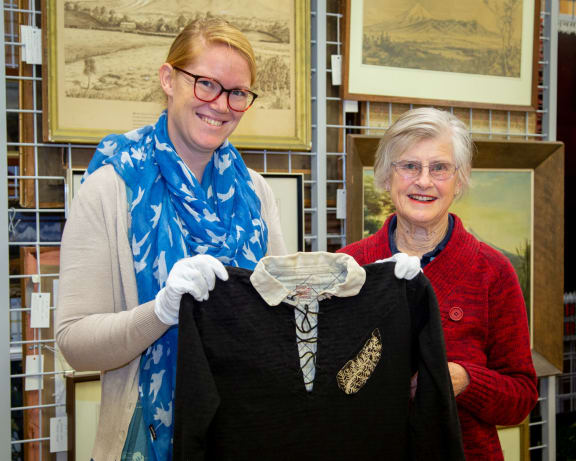 Puke Ariki social history curator Megan Wells and Vivienne Brown with Handley Brown’s All Blacks jersey from the Invincibles tour.