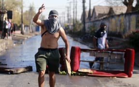 A demonstrator gestures during clashes with riot police within a protest against Chilean President Sebastian Pinera's government amid the Covid-19 pandemic.
