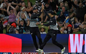 New Zealand's Tim Robinson, left, and Mark Chapman celebrate Robinson's catch that removed Sir Lanka danger man Pathum Nissanka during the first T20 international at Mt Maunganui, 28 December 2024.