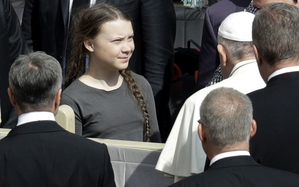 Pope Francis, back to camera, greets Swedish teenage environmental activist Greta Thunberg, during his weekly general audience in St. Peter's Square, at the Vatican, Wednesday, April 17, 2019. (AP Photo/Gregorio Borgia)