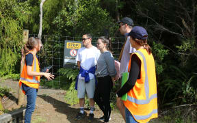 Auckland Council officers talk to trampers in the Waitākere Ranges.