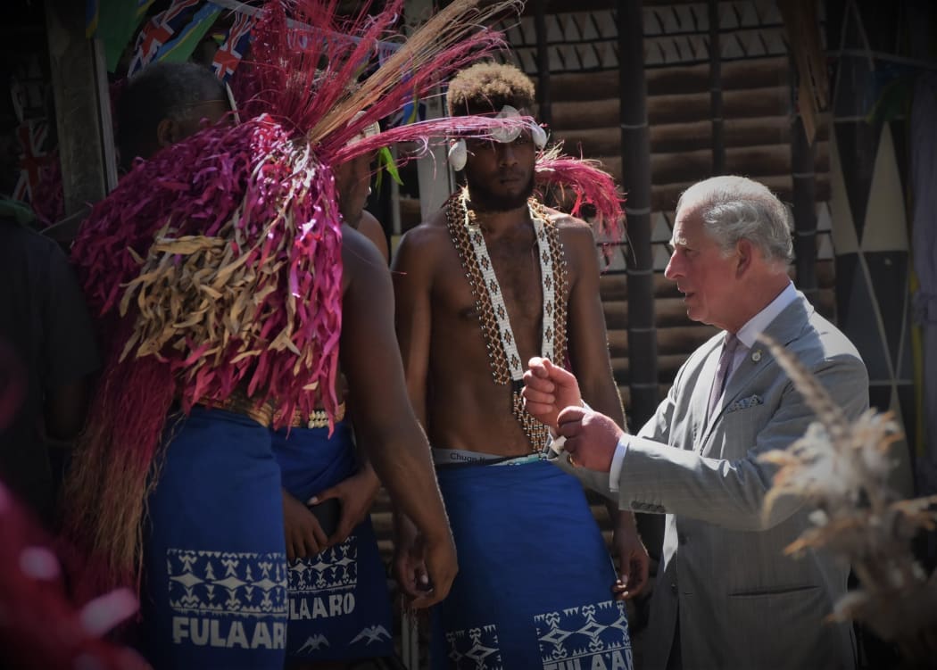 Prince Charles speaks with traditional dancers in Solomon Islands.