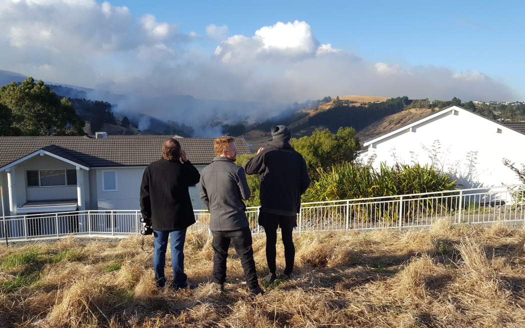 Henry Reese, centre, watches his family home burn to the ground