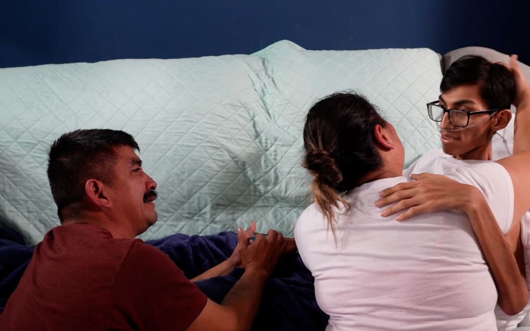 Kevin González, 18, with his parents.