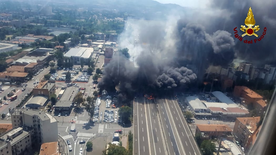 Black smoke rises in the sky after a tanker exploded on the motorway close to the airport, in Bologna.