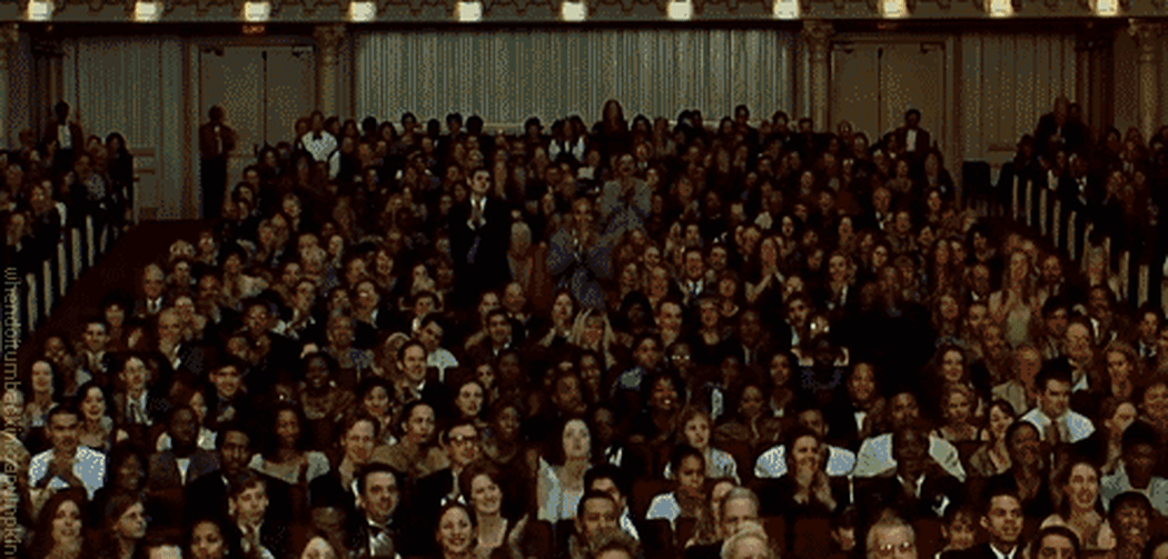 A gif of a theater full of people applauding.