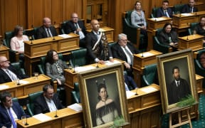 Hamilton West MP Tama Potaka delivers his maiden statement in Parliament with life-size portraits of his ancestors in the foreground, 7 March 2023.
