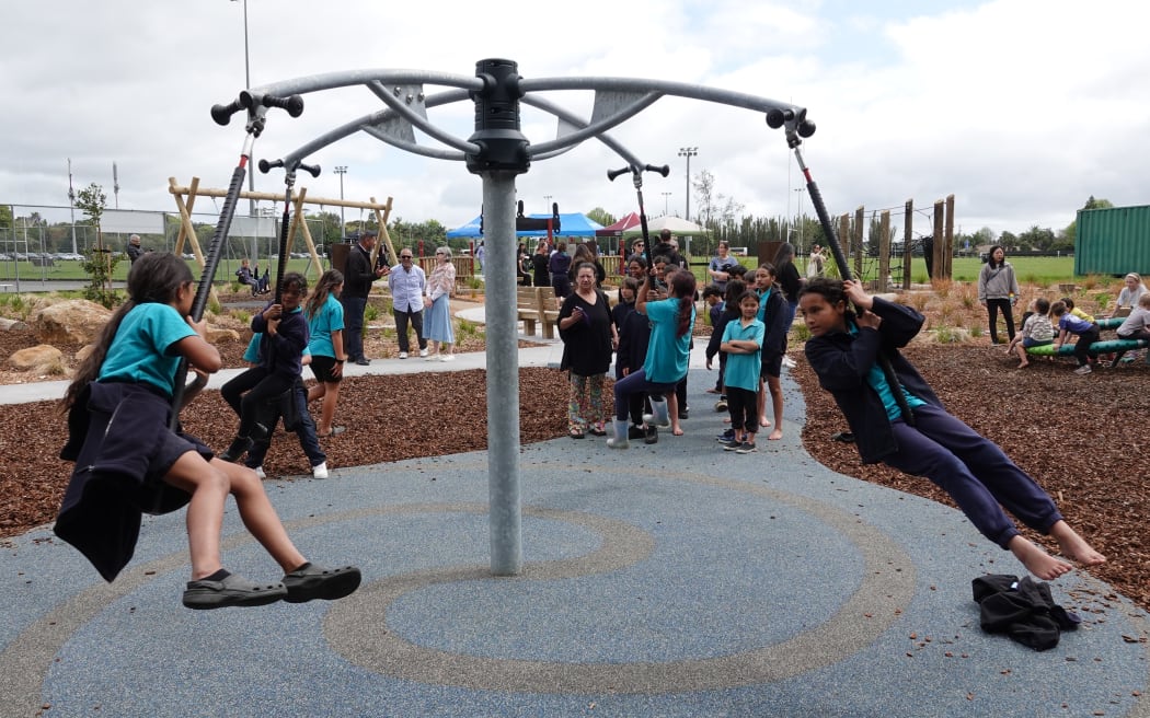 Kids line up to test the playground equivalent of a merry-go-round.