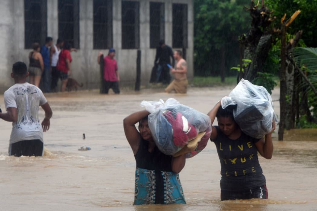 Local residents save their belongings at the Alemania suburb,  due to the heavy rains caused by Hurricane Eta,  in the city of El Progreso, department of Yoro, 260 kms north of Tegucigalpa, on November 4, 2020. -