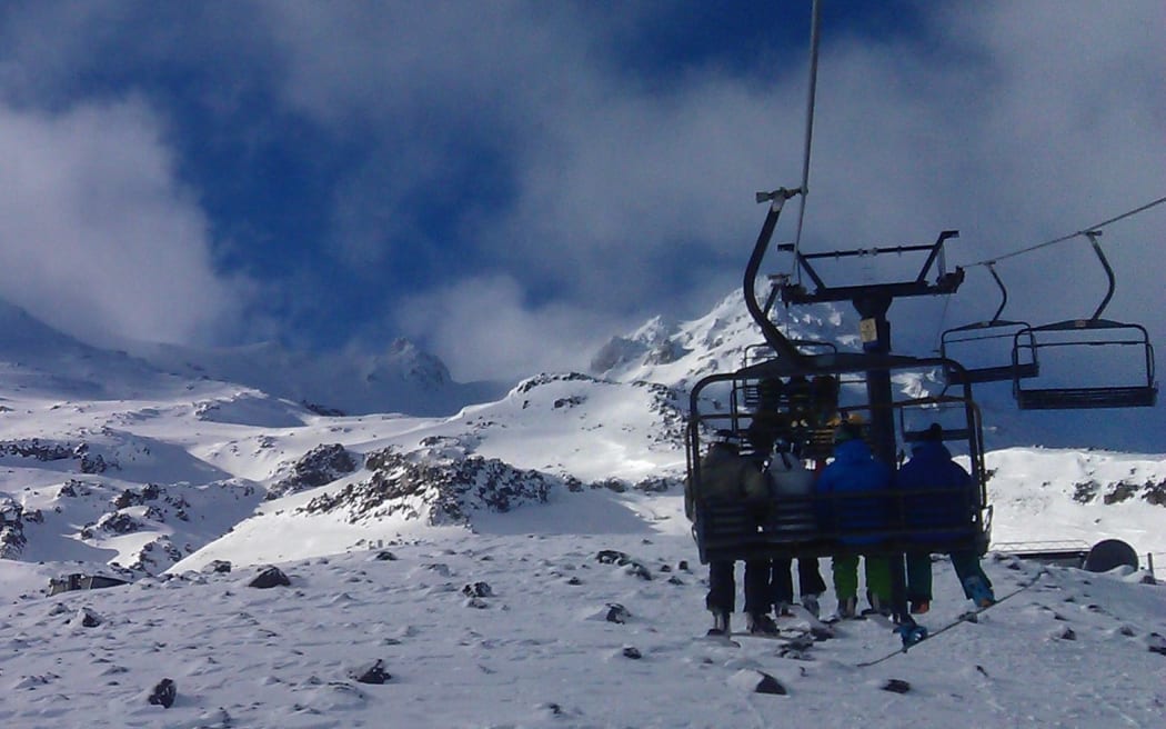 Skiers on a chairlift at Turoa ski field.