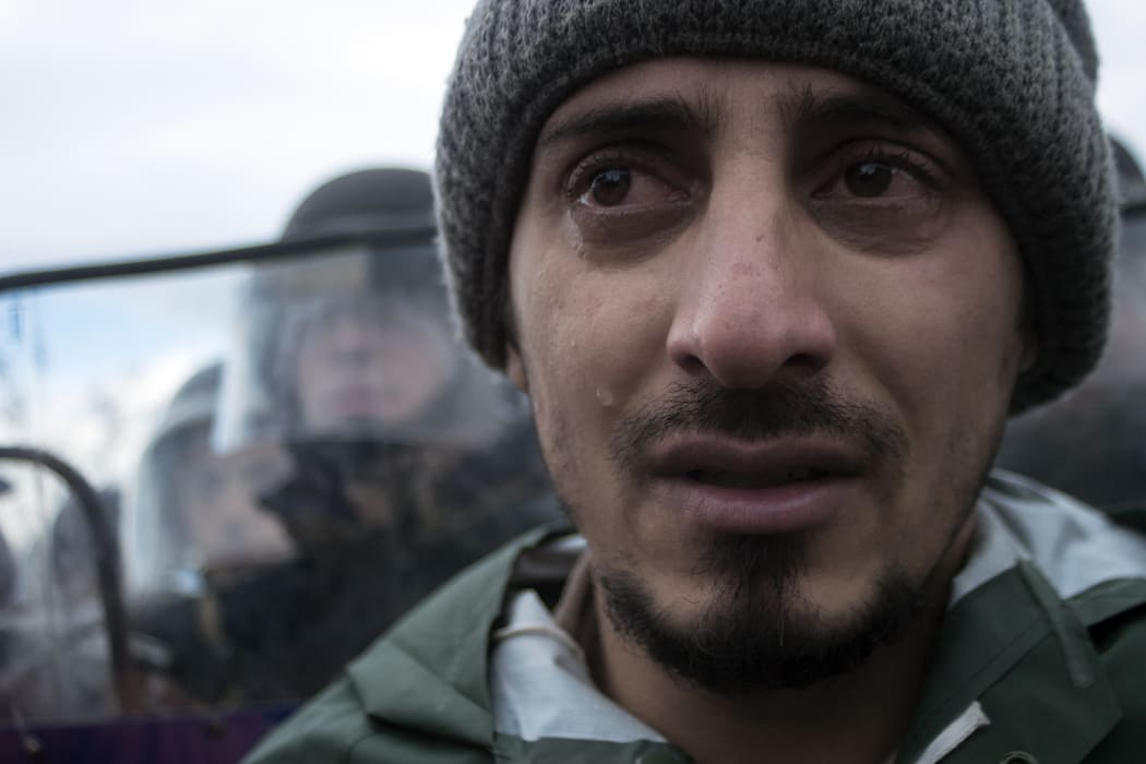 A stranded refugee reacts during clashes between refugees and police at the Macedonia-Greece border