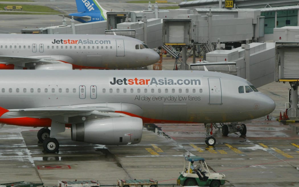 Two Jetstar Asia Airbus A320 planes are berth at the Terminal One of Singapore Changi Airport in Singapore, 13 December 2004. Jetstar Asia takes to the skies for the first time when its maiden flight to Hong Kong departs Singapore's Changi airport 13 December.