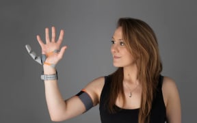 Dani Clode demonstrates her third thumb prosthetic.