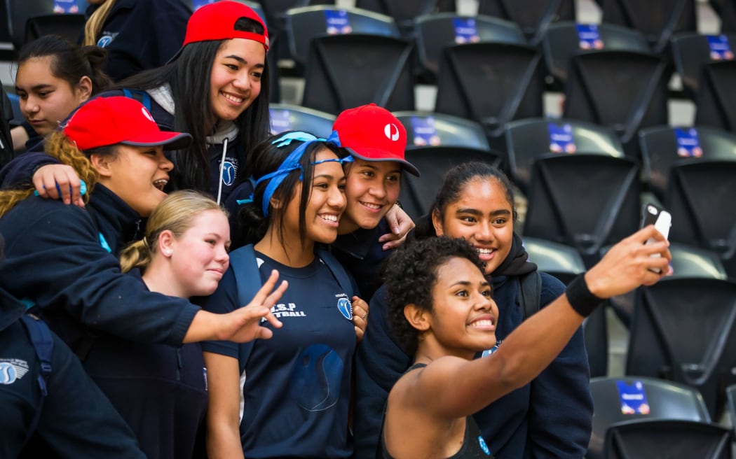 Fiji's Episake Kahatoka takes a photo with fans at the Netball World Cup.