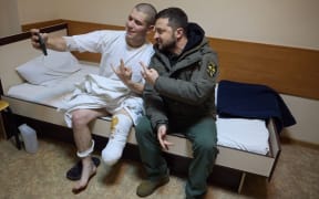 This handout picture taken and released by the Ukrainian Presidential press service on December 6, 2022, shows Ukrainian President Volodymyr Zelensky (R) posing for a picture with a wounded Ukrainian soldier in a hospital during his visit to Kharkiv region amid the Russian invasion of Ukraine. - President Volodymyr Zelensky on December 6, 2022 visited the frontline region of Donetsk in east Ukraine, describing fighting in the area as "difficult" with Russian forces pushing to capture the industrial city of Bakhmut. (Photo by STRINGER / UKRAINIAN PRESIDENTIAL PRESS SERVICE / AFP) / RESTRICTED TO EDITORIAL USE - MANDATORY CREDIT "AFP PHOTO /  Ukrainian Presidential press service " - NO MARKETING NO ADVERTISING CAMPAIGNS - DISTRIBUTED AS A SERVICE TO CLIENTS