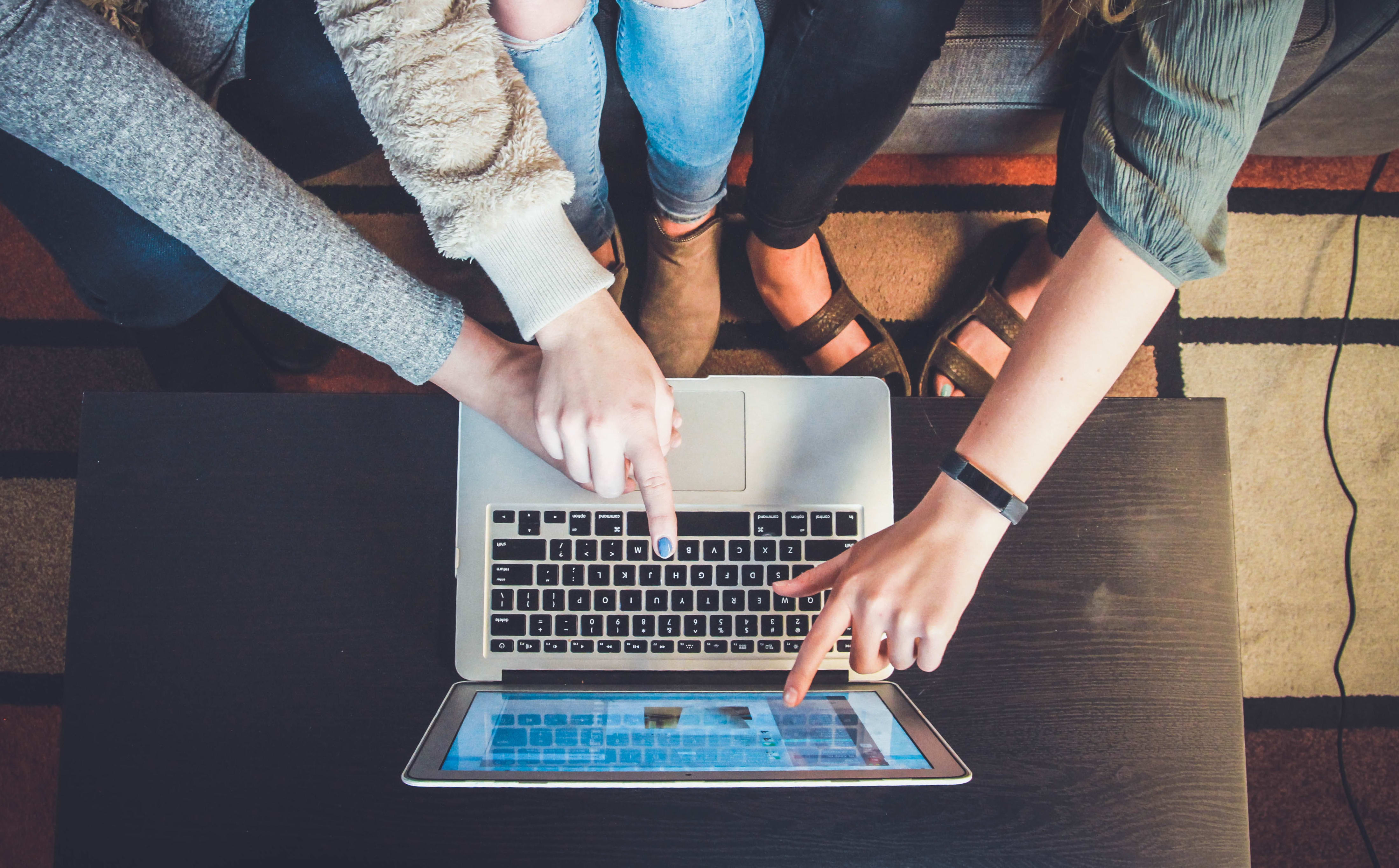 three girls looking at a laptop