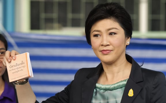 Yingluck Shinawatra shows her vote at a ballot box at a Bangkok polling station.