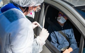 A nurse from the Gerard Noet analysis laboratory in the 10th arrondissement of Paris, performs a coronavirus screening test known as pcr test on drive-in patients.