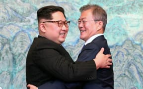 North Korea's leader Kim Jong Un (L) and South Korea's President Moon Jae-in (R) hug during a signing ceremony near the end of their historic summit