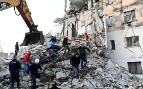 Emergency workers clear debris at a damaged building in Thumana after an earthquake hit Albania, on 26 November, 2019.