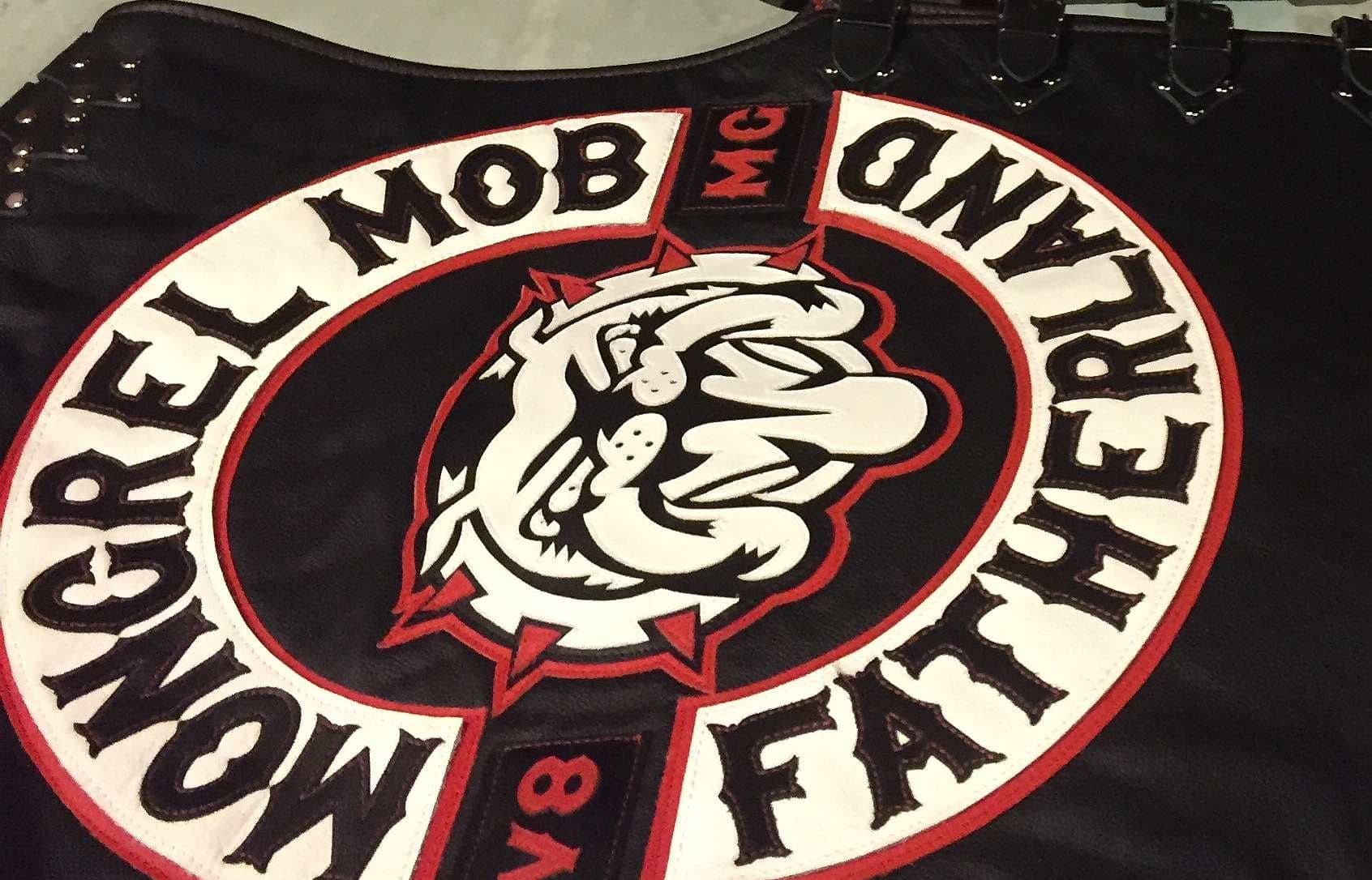 New Mongrel Mob patches on black leather  jerkins with Mongrel Mob, a bull dog and  Fatherland, lie on a table
