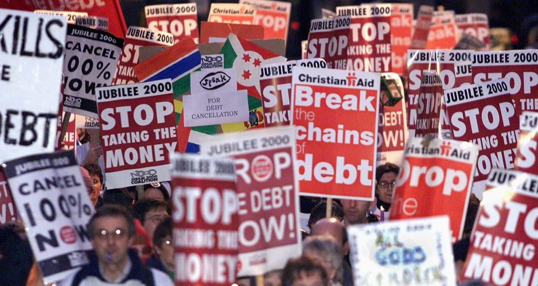 Banners are carried through the streets of London for the Jubilee 2000 March in aid of Western countries cancelling third world debt (2 December, 2000)