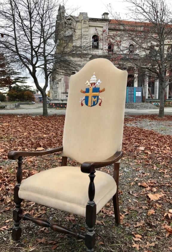 An image Pope John Paul II's chair sitting in front of the Catholic Cathedral of the Blessed Sacrament.